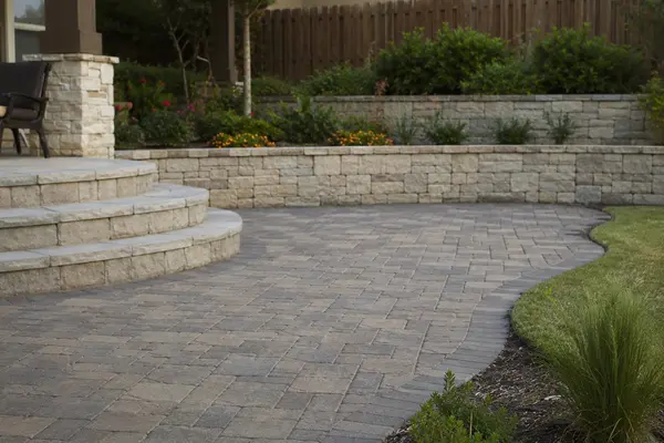 Hardscaping in Georgetown, TX with a paver patio and stone retaining wall built for Central Texas clay soil.